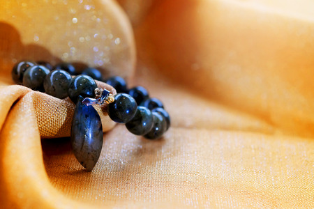 Labradorite lucky stone on golden fabric background. Amulet accessories for good lucky fortune and happy lifeの写真素材