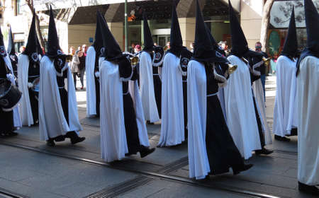 Nazarene penitents in black and white with ceremionial trumpets during the Easter Holy Week...