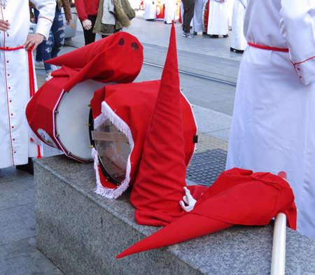 Nazarene penitents red caps and drums during Easter Holy Week procession in Spain