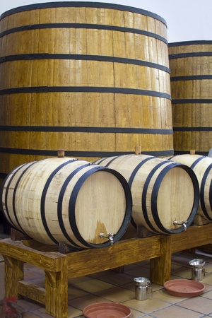 Big and small wooden wine casks. Wine cellar.