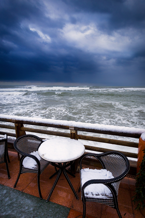 The snow which has covered furniture on the embankment of the warm seaの写真素材