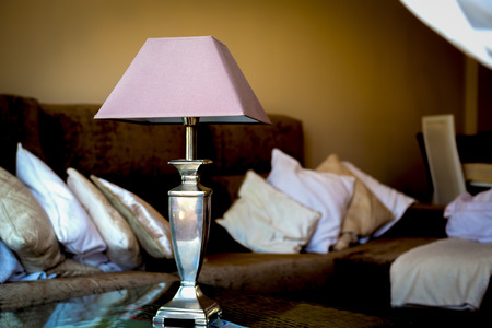 Desk lamp against the background of a sofa with pillowsの写真素材