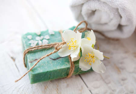 Spa composition with  jasmine blossom  towel and  handmade soap on white wooden tableの写真素材