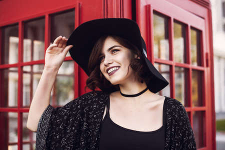 Stylish British portrait of a charming young woman with short hair. brunette in a fashionable hat...