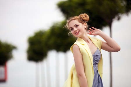 young sexy girl hipster beautiful blonde with red lips close-up portrait Dressed in a yellow jacket looking at the camera.の写真素材