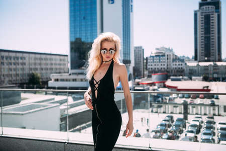 Female fashion concept. Outdoor waist up portrait of young beautiful woman posing on old street. Model wearing stylish clothes, looking at camera. Sunny day. City lifestyle. Copy, empty space for textの写真素材