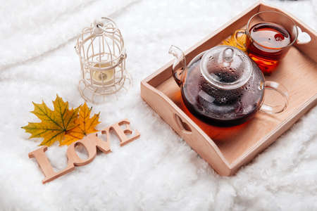 autumn home scene, Scandinavian style. A warm knitted sweater, candles, a cup of warm tea and other...