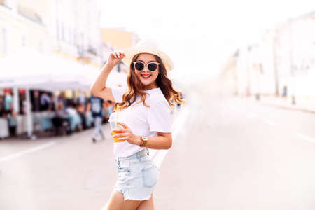 Adorable girl enjoying festive in amusement park. Outdoor photo of blissful female model with...