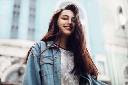 close-up portrait of a young sexy brunette hipster girl. girl is dressed in a stylish large denim jacketの写真素材