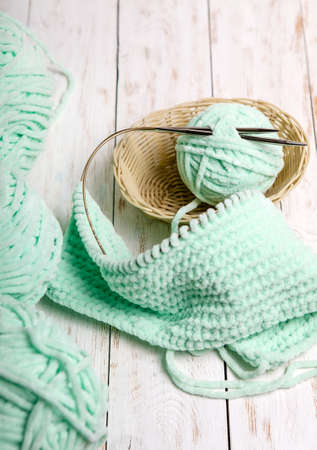 Balls of yarn in basket with knitting needles.Skeins of wool and knitting needles on a wooden background.の写真素材