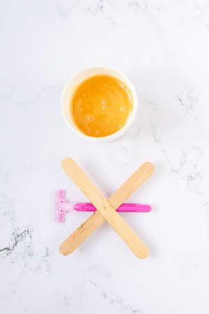 depilation and beauty concept - sugar paste or wax honey for hair removing with wooden waxing...