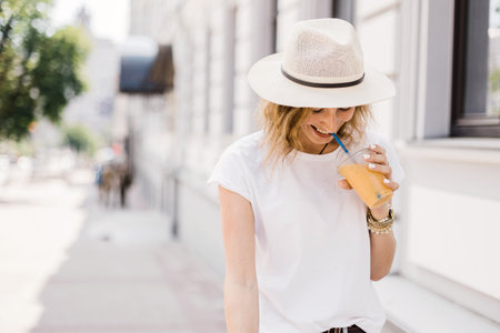 atmosphere of summer. young girl drinks bright lemonade on a city street