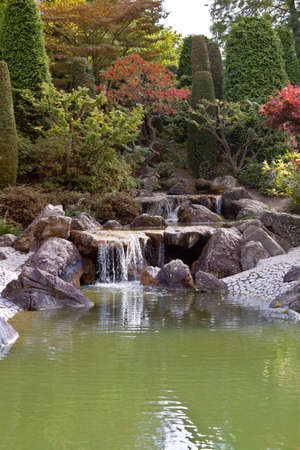 Japanese garden with a waterfall in autumnの写真素材