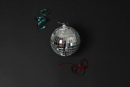 disco ball on a black background with two ribbons near