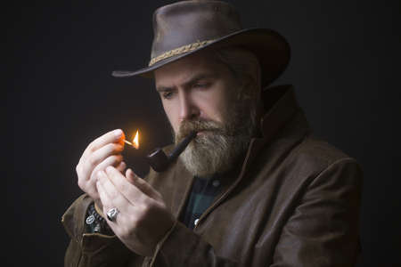 Man holding tobacco pipe, old habits concept.