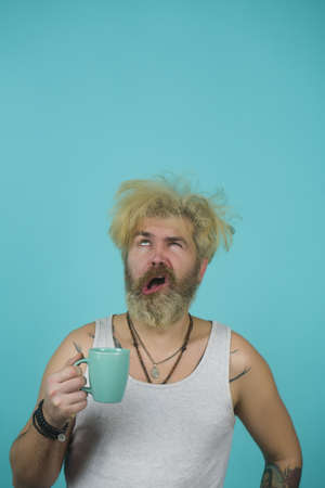 Young handsome man with a headache the morning after night out drunk.の写真素材