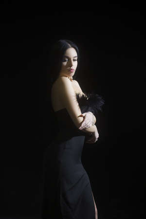 Fashion studio portrait of young beautiful female model in black sexy dress. Glamour photo of pretty...
