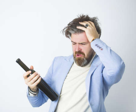 Man with gray hair and beard with alcohol wearing blue jacket.の写真素材