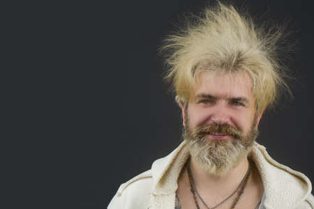 Goofy young man, with full beard and moustache and wild hair, pull a comical face to the camera. Space for your text.の写真素材