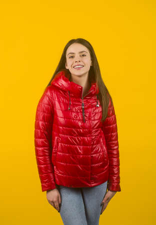 Beautiful stylish woman wearing red jacket. Fashionable and self-confident girl with long curly hair. Clothing, style and fashion.の写真素材