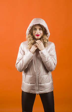 Blonde woman in grey jacket and hood on the head. Beauty, fashion. Copy space.の写真素材