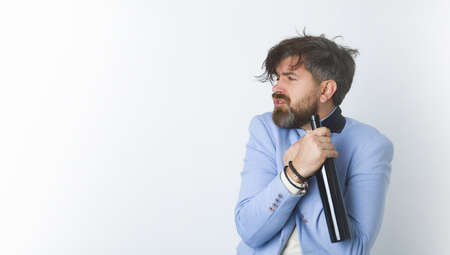 Drunk and lonely man holding a rum or wine bottle.