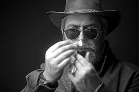 Handsome moustache and beard hipster man smoking pipe.の写真素材