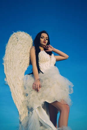 Portrait of beautiful brunette woman with angels wings. Angel with long curly hair.の写真素材