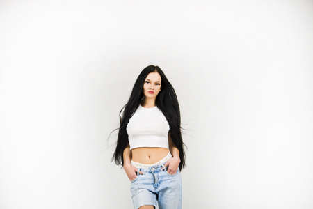White t-shirt and real young female Caucasian model with long hair clothing in jeans pants and...