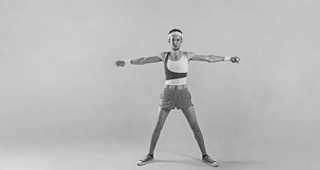 Funny retro sport nerd lifting weights on yellow background.の写真素材