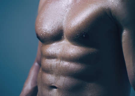 Sexy man or muscular macho, bodybuilder, with muscle torso, body with six packs and abs poses.の写真素材