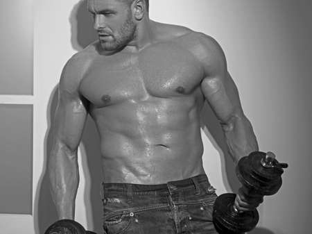 Sporty muscular guy with dumbbells. Sport and fitness motivation. Individual sports recreation.の写真素材