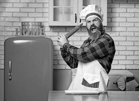 Young bearded chef angry or banging on someone on kitchen.の写真素材