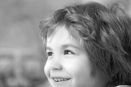 Close up portrait of an excited little boy laughing.