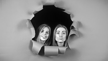 Young pretty women or girls breaking through a paper sheet.の写真素材