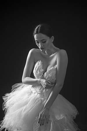 Beautiful sexy girl with white dress against dark background.の写真素材