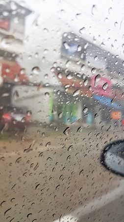 Drops of rain on the car glass with the urban backgroundの写真素材