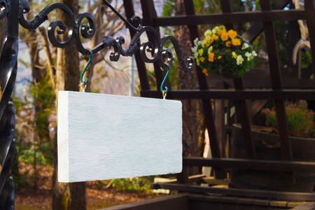 White wooden sign hanging on a black steel beam.の写真素材