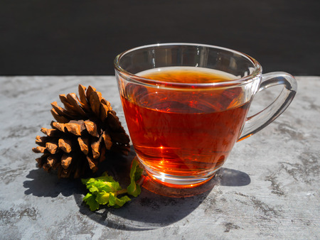 Hot tea in a clear glass that is placed on a dark gray table and decorationの写真素材