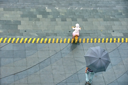 Father and daughter in the streets of Taipei, rain in.の写真素材