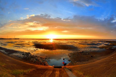 Seaside sunset with colorful cloudの写真素材