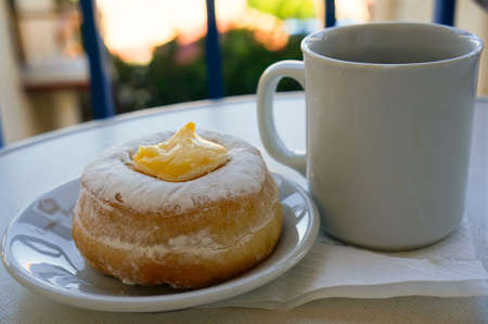 Donut with a cup of tea on the balcony of a close-upの写真素材