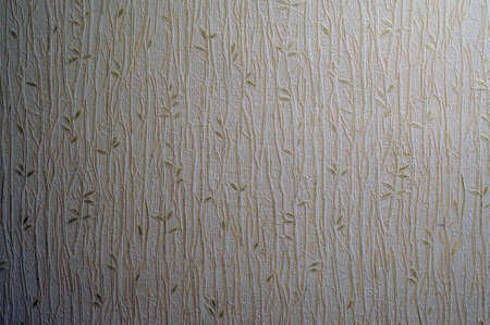 Light creamy texture of wallpaper with a pattern of golden sprigs