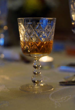 Crystal glass of amber wine at candlelight                               の写真素材