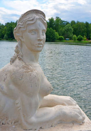 White marble sphinx against the backdrop of the pond                               の写真素材