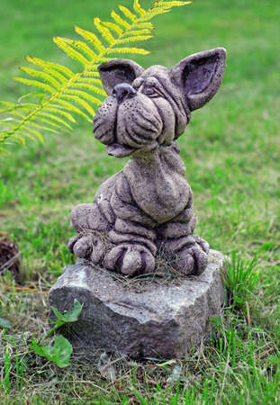 Garden stone statue of dog on the lawnの写真素材