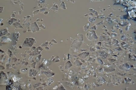 Shattered ice on gray water as a backgroundの写真素材