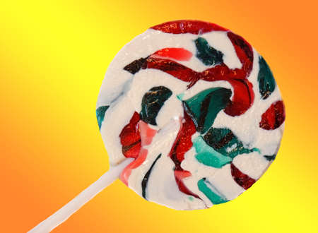 Bright round lollipop  on yellow-orange backgroundの写真素材