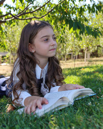 Cute little girl reads a bookの写真素材