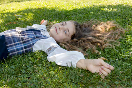 Cute little girl lying on the grassの写真素材